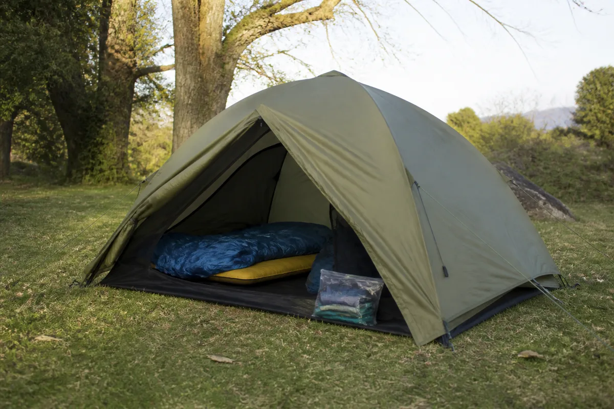 Tente de festival montée avec sac de couchage et matelas sur un terrain de camping